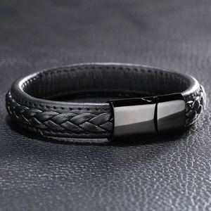 Detailed macro of black braided leather bracelet with glossy magnetic metal clasp