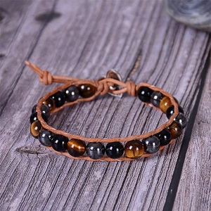 Detail of woven lava stone bracelet with tiger eye beads and heart-shaped metal clasp