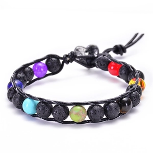 Detail of seven chakra beads with black lava stone and silver heart charm on woven bracelet