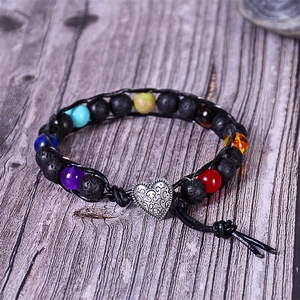 Detailed view of natural lava stone and tiger eye beads on braided leather strap bracelet