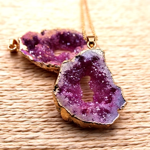 Macro de colgante de ágata druzy púrpura natural con borde chapado en oro sobre tela