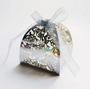 Silver hollow floral wedding favor box featuring a light blue ribbon on white background