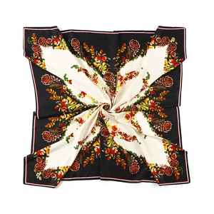 Floral print twill silk scarf with butterfly pattern folded in spiral on white background