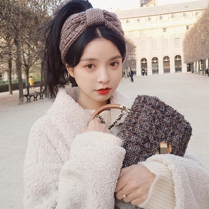 Detail of coffee brown knitted bow headband styled with a chic winter vintage street outfit