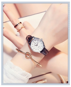 Close-up of elegant KEZZI women's quartz watch with black leather strap and silver dial