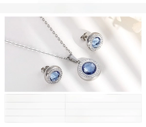 Detail view of round blue crystal pendant and matching stud earrings jewelry set