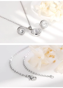 Detail view of silver-tone round crystal pendant necklace and matching stud earrings set