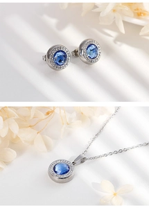 Detail of silver jewelry set with blue round crystals and shimmering micro-inlay accents