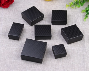 Detail view of black diamond-textured jewelry gift boxes in various sizes with rose decor