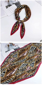 Détail d'un foulard en soie plissé avec motifs léopard, zèbre et chaînes dorées