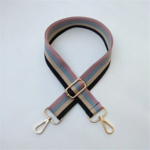 Close-up of adjustable striped bag strap with gold-tone metal buckles and lobster clips