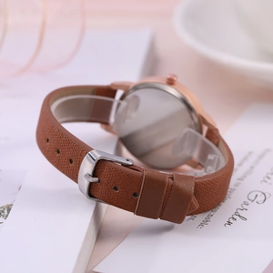 Dettaglio del cinturino in pelle marrone e cassa in oro rosa di un orologio donna