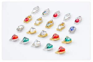 Macro detail of assorted heart and teardrop nail art crystals in gold and silver settings