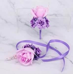 Detail of purple silk rose boutonniere and wrist corsage set for wedding ceremonies