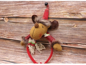 Detail of red plaid reindeer headband with hat and scarf on rustic wood background