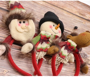 Close-up of plush Santa, Snowman and Reindeer Christmas headbands on dark wood
