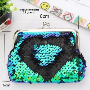 Detail view of heart-shaped sequin coin purse with reversible black-blue gradient finish
