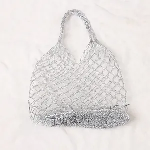 Detail einer silbernen Netzhandtasche mit Metallic-Finish und gewebter Netzstruktur