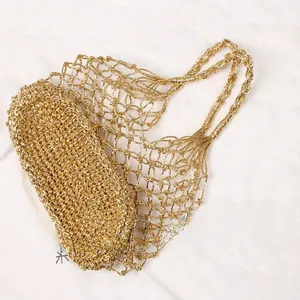 Detailansicht der gold gewebten Netztasche mit ovalem Boden und grober Netzstruktur