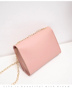 Side view of pink PU leather crossbody bag with elegant gold metal chain strap