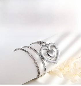 Detailed view of silver heart pendant featuring layered dual chains and polished finish
