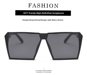 Detailed close-up of oversized square sunglasses with black flat-top frame and dark lenses