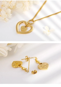Detailed macro view of gold hollow heart necklace and stud earrings with Love engraving