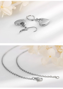 Dettaglio di collana e orecchini a cuore in argento con eleganti accenti floreali bianchi