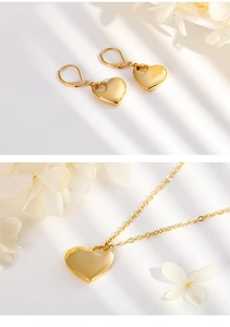 Dettaglio del set collana e orecchini a cuore dorati con decorazioni floreali