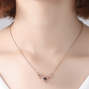 Rose gold deer antler necklace with crystal pendant shown on a model neck