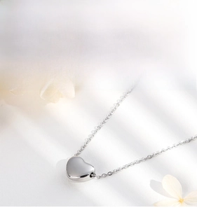 Detail of polished stainless steel heart pendant necklace with high gloss finish texture