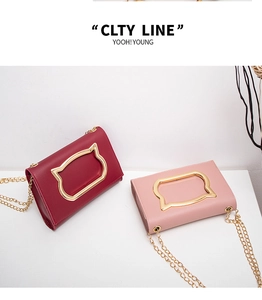 Detail of crossbody chain bags with gold cat-shaped handles in red and pink colors