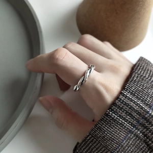 Minimalist 925 sterling silver woven twist ring worn by a model in a refined setting