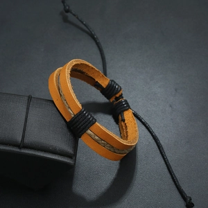 Macro view of woven yellow leather bracelet with hemp rope detail on black display stand