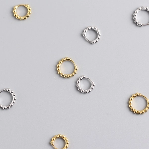 Minimalist s925 silver beaded hoop earrings in gold and silver finish on grey background