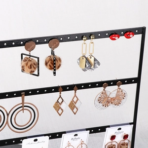 Multi-tier black metal earring display stand showcasing various stylish stud earrings
