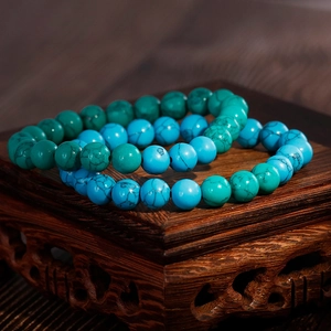 Fashionable turquoise beaded bracelets featuring green and blue round stones on wood base