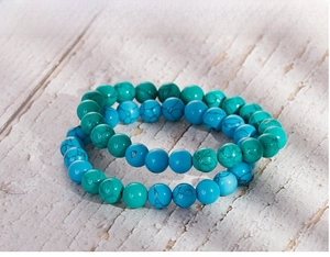 Macro detail of elastic beaded bracelets with natural turquoise texture on wood