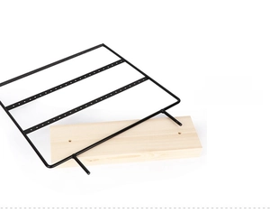Detail of minimalist 4-tier black metal earring organizer with a solid wood base