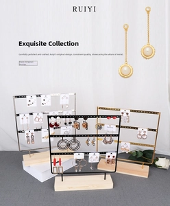 Macro detail of multi-tier metal earring display stand with natural wooden base