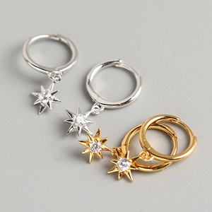 Macro shot of gold and silver S925 sterling silver star earrings with cubic zirconia detail