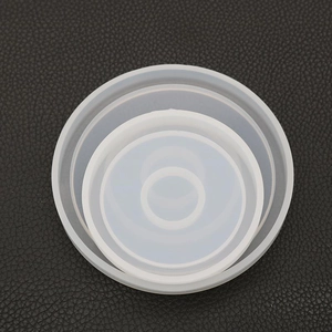 Nesting circular silicone molds for DIY resin coasters on a textured black background