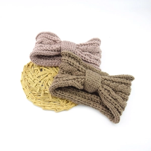 Close-up of thick cable knit bow headbands in dusty pink and coffee brown colors