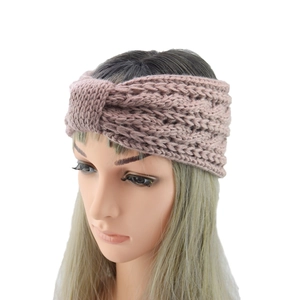 Detailed close-up of thick cable knit texture on a dusty pink bow headband for women