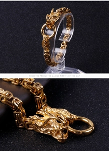 Macro detail of golden dragon heads buckle and square link chain on men's bracelet