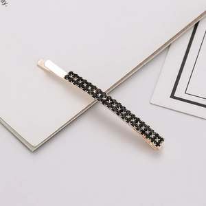 Close-up of double-row black crystal hair clip with golden base and metal alloy finish