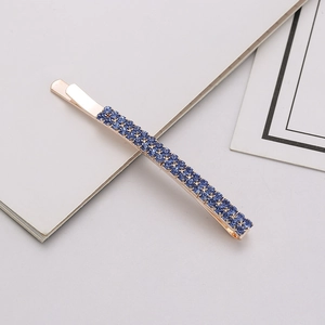 Detailed view of rose gold clip featuring three rows of navy blue rhinestones