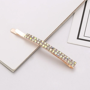 Close-up of double-row AB crystal rhinestones on a slim golden metal hair clip