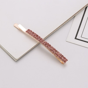 Detail view of double-row purple rhinestones on a rose gold metal hair clip