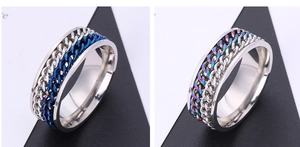 Detail of stainless steel spinner rings featuring blue and rainbow Cuban link chains